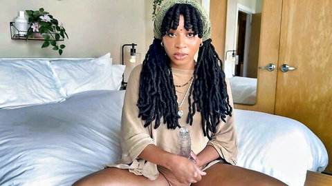 Ebony babe with dreads spreads legs wide holding clear dildo at shaved black pussy