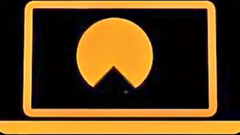 Glowing orange Pac-Man logo with open mouth on black screen frame