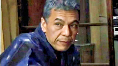 Japanese mature man with gray hair in dark jacket, intense gaze