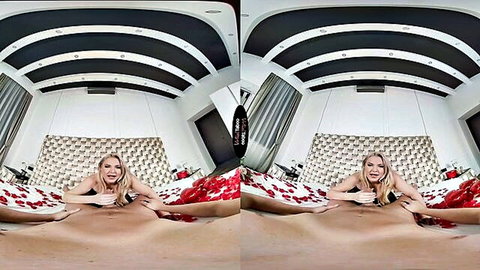 Blonde bombshell spreading legs wide on rose petals in seductive POV pose