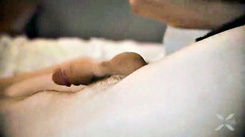 Close-up of woman's pale thigh and erect penis on white bed sheets, explicit intimacy
