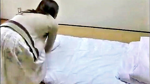 Japanese woman in skirt bending over bed, teasing upskirt view in JAV
