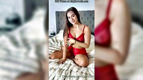 Seductive brunette in red lingerie posing teasingly on bed