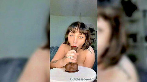 Oiled PAWG brunette teases with massive brown dildo orally