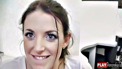 Angela White smiling seductively in white blouse, library tease