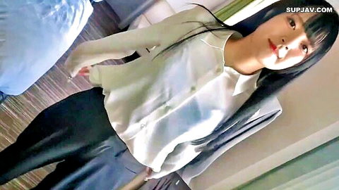 Seductive Japanese babe in sheer white blouse and tight black pants teasing in hotel room