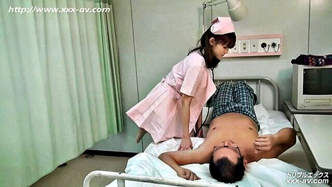 Japanese nurse in pink uniform checks stethoscope on shirtless patient's bare chest in hospital bed