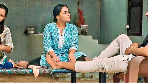 Two Indian women in traditional attire sitting with bare feet beside casual man