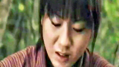 Close-up of cute Japanese woman with black bangs smiling in forest, striped shirt