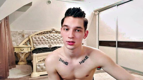 Shirtless young twink Teddy Mode with chest tattoos posing seductively