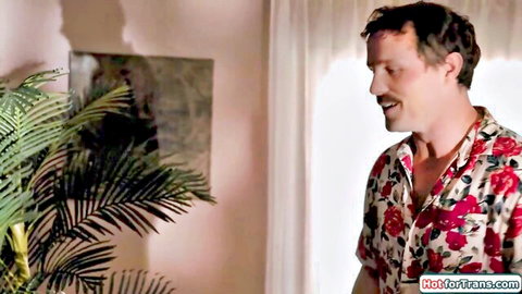 Handsome brunette man smirks seductively in open floral shirt exposing hairy chest