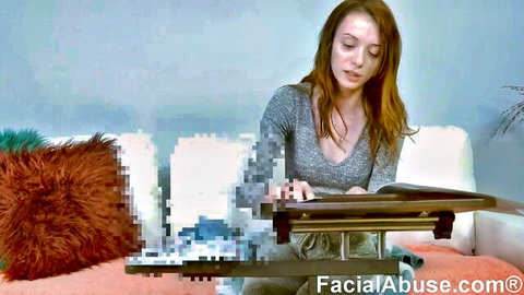 Redhead babe in gray sweater sits on couch with lap desk over pixelated tits and pussy at FacialAbuse