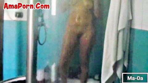 Skinny fair-skinned brunette standing nude in steamy shower with wet pussy and medium tits visible
