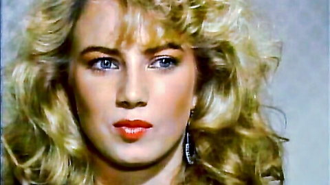 Vintage blonde babe with big hair, blue eyes and glossy red lips in seductive closeup