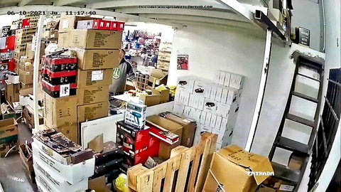 Warehouse worker bending over boxes in afternoon shift