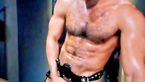 Hairy muscular man in low-slung pants showing ripped abs and holster belt