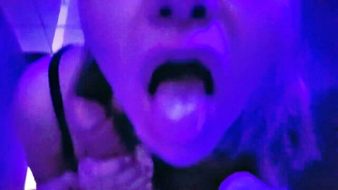 Closeup of horny babe sticking out wet tongue in open mouth ready for cock in neon bathroom