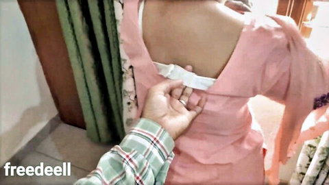 Indian couple foreplay, man unbuttoning woman's pink dress from behind
