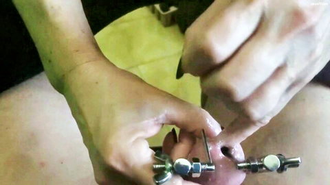 Female hands inserting metal sounding rods into erect penis, BDSM fetish