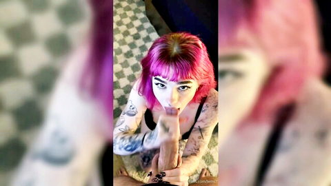 Tattooed pink-haired girl giving close-up blowjob