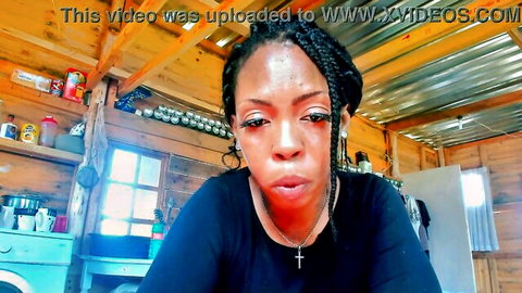 Sexy ebony woman with braids purses plump lips seductively in black top