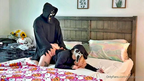 Ghostface masked man fucks curvy woman's exposed pussy doggy style on Halloween bed