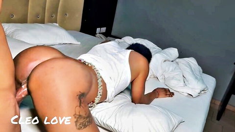 Woman's hand gropes muscular black man's bare ass cheek on bed