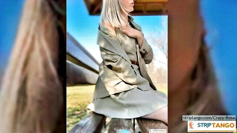 Blonde in open beige coat flashing fishnet stockings on outdoor bench