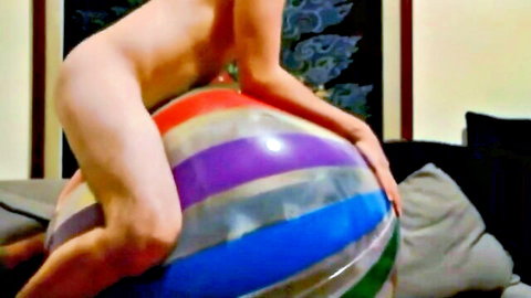 Nude woman grinds bare ass and pussy on giant colorful inflatable beach ball