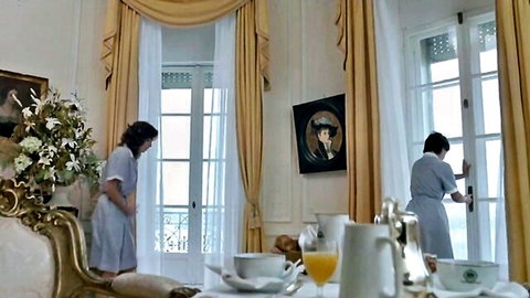 Two mature brunette French maids in short blue dresses bending over luxury breakfast table