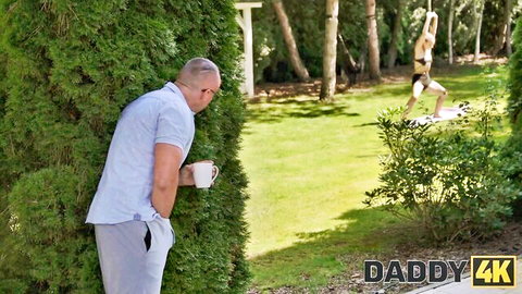 Old man peeks through bushes at young skinny brunette exposing small tits and shaved pussy in outdoor handstand on swing