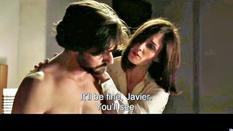 Paz Vega as Consuelo comforts shirtless Javier in dramatic embrace