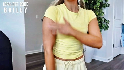 Bailey blonde fitness model in yellow crop top and sweats, try-on pose