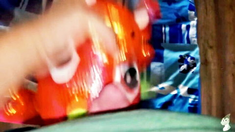 Blurry close-up of hand gripping crimson dragon dildo in playful adult fun