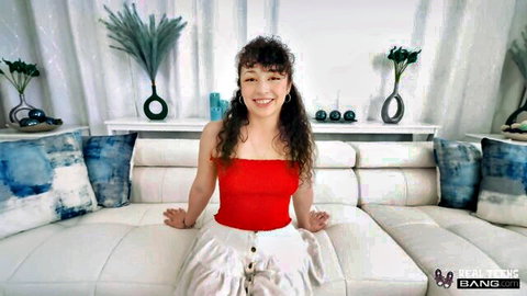 Brunette teen Pixie Smalls smiles in red strapless top and white skirt