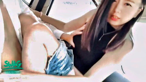 Sexy Asian woman teasing in car with short denim shorts