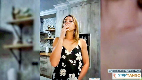Blonde housewife in floral dress seductively smokes cigarette in kitchen teasing her big tits cleavage