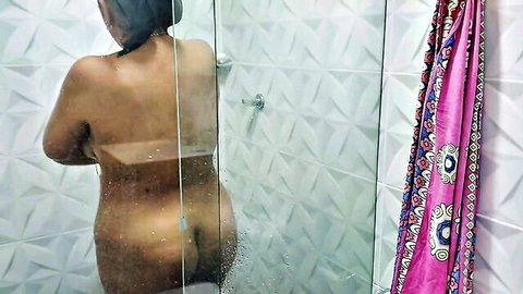 Naked curvy Indian woman with big ass showering nude from behind through glass door