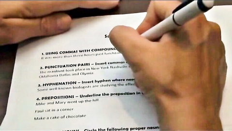 Closeup of English grammar worksheet on commas, punctuation, and proofreading exercises with pen.