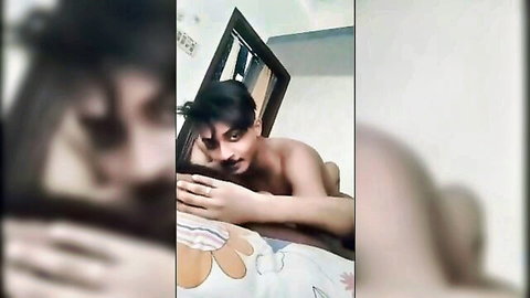 Young naked Indian guy with big erect cock smiling on colorful bed in amateur selfie