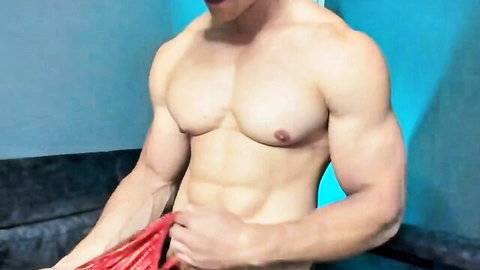 Hot muscular Latino camboy posing shirtless, showcasing chiseled abs and chest with red towel