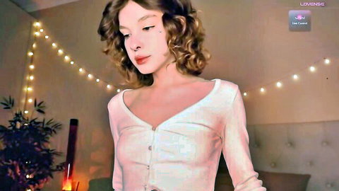 Curly haired webcam girl teases deep cleavage in open white cardigan solo