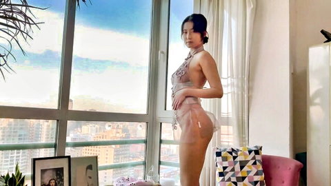 Asian beauty in sheer transparent lingerie posing by window revealing perky tits and juicy ass