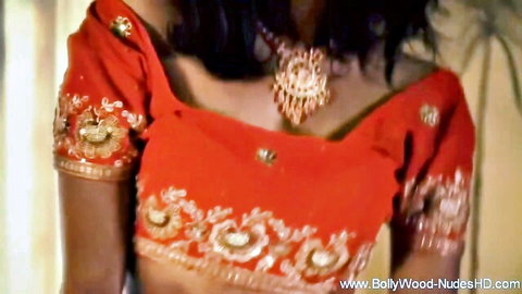Sexy Indian brunette in tight red choli blouse showing deep cleavage and huge tits