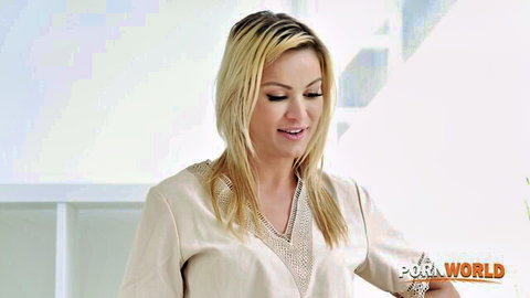 Seductive blonde MILF cougar smiling teasingly in embroidered low-cut blouse