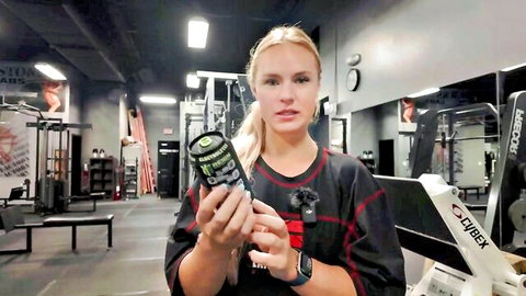 Muscular blonde babe holds Monster energy drinks in steamy gym teasing her fit curves