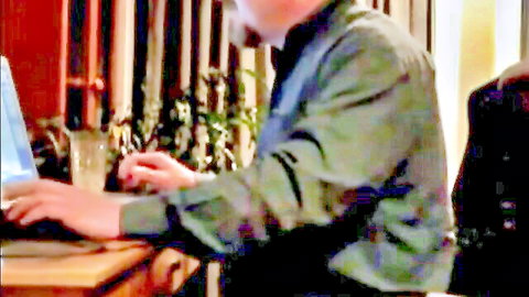 Mature daddy bear in green shirt typing on laptop