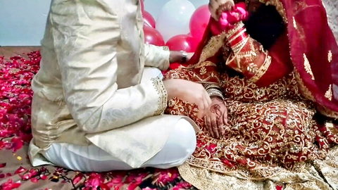 Indian bride in red saree and groom in traditional attire on wedding night