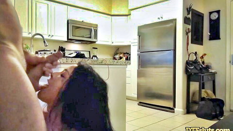 Tanned big tits girl in kitchen exposes boobs while sucking fingers from above POV