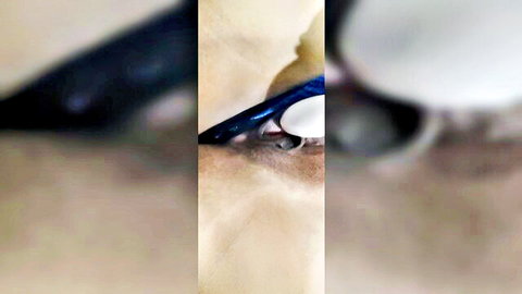 Close-up of woman's eye with blue mascara wand applying to lashes, blurry amateur shot